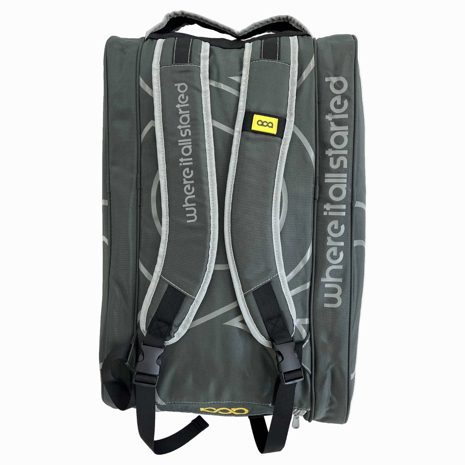 Rückseite der Tasche mit gepolsterten Tragegurten und dem vertikalen Schriftzug 'where it all started'.