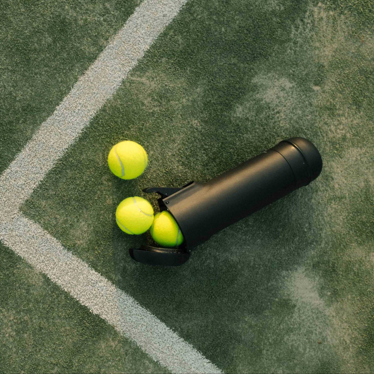 Der Bounce Druckluftbehälter auf dem Padel Court liegend mit Bällen – das ideale Zubehör für nachhaltiges Spielen.