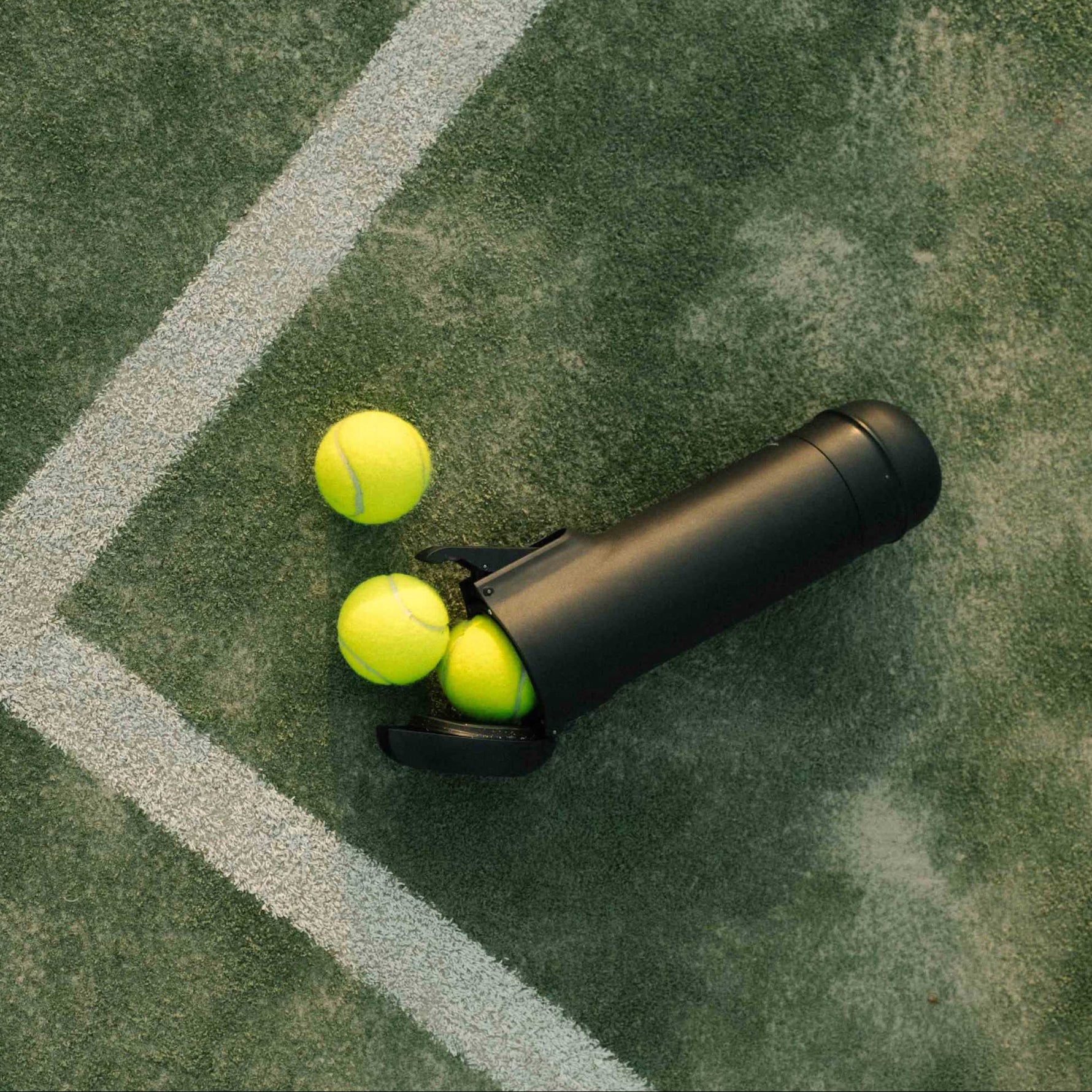 Der Bounce Druckluftbehälter auf dem Padel Court liegend mit Bällen – das ideale Zubehör für nachhaltiges Spielen.