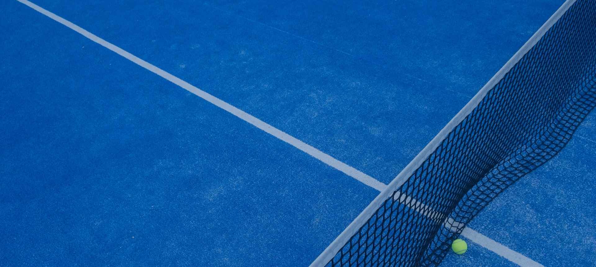 Ein blauer Padel-Court mit Netz und Ball. Kontaktiere den Courtcrusher Onlineshop.