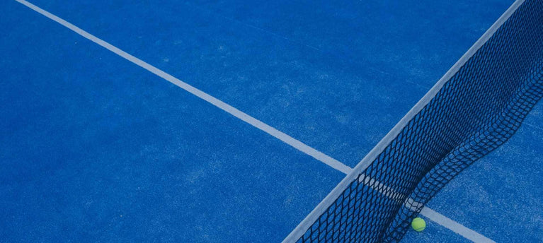 Ein blauer Padel-Court mit Netz und Ball. Kontaktiere den Courtcrusher Onlineshop.